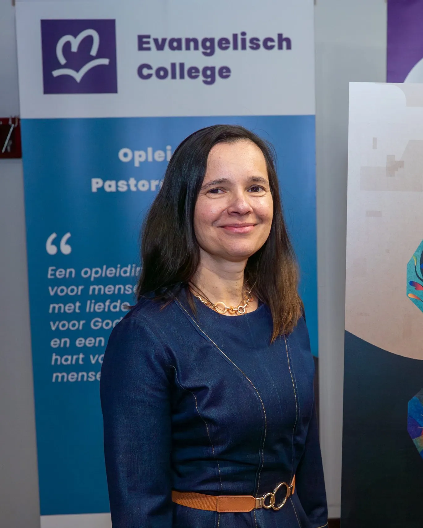 Anca Hamelink-Popescu, voor de banner van het Evangelisch College.